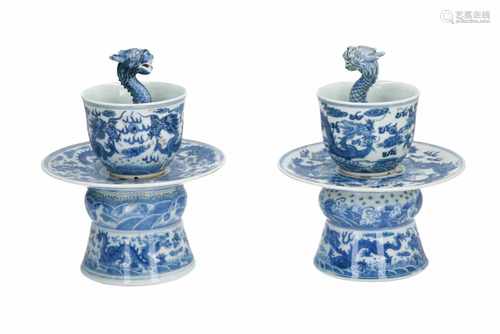 A pair of blue and white porcelain dragon puzzle cups on stand, decorated with dragons. Marked