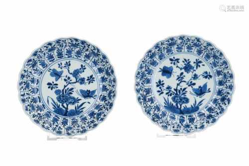 A pair of blue and white porcelain saucers with scalloped rim, decorated with flowers and