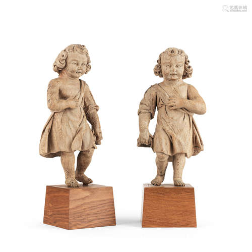 A pair of late 17th century carved oak putti, or 'boyes', circa 1670