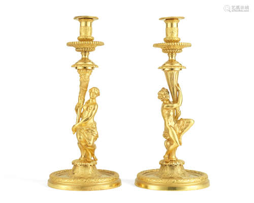 in the manner of Corneille van Clève (French, 1645-1732) A pair of gilt bronze Régence style figural candlesticks