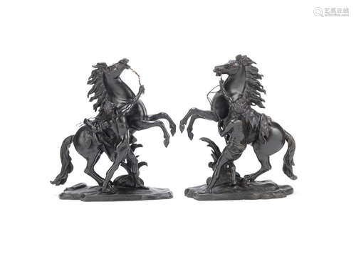 After Guillaume Coustou the elder (French, 1677-1746): A pair of late 19th / early 20th century patinated bronze models of the Marly Horses