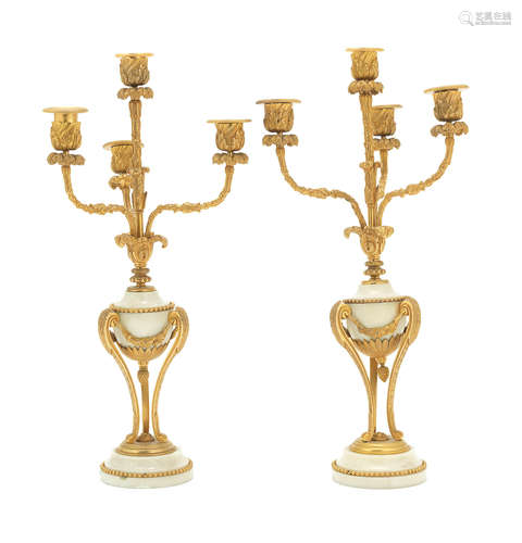 in the Louis XVI style, probably  late 19th / early 20th century A pair of French gilt bronze mounted white marble four light candelabra