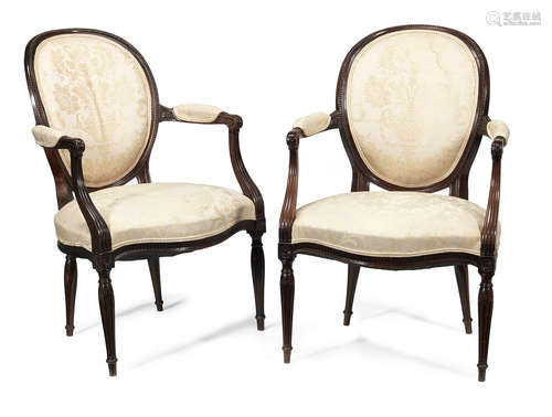 A pair of George III carved mahogany open armchairs