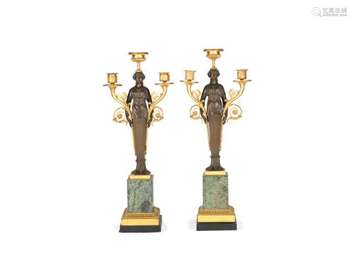 in the Empire style, probably early 20th century A pair of French gilt and patinated bronze and marble three light figural candelabra