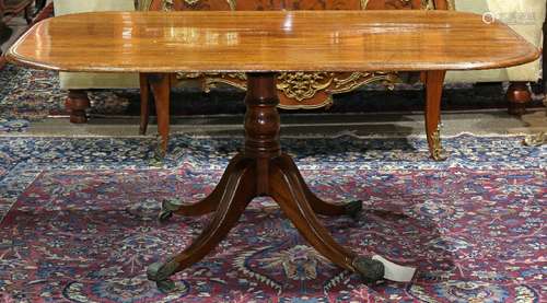 Regency mahogany breakfast table, circa 1820, having a shaped top, above a baluster standard, and