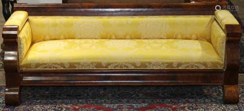 Empire mahogany settee, circa 1820, having a shaped back, above yellow upholstery and rising on