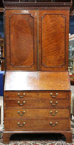 George III plum pudding mahogany secretary bookcase, late 18th century, having a molded top with dentil accents, above two paneled d...