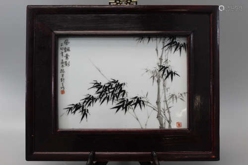 A framed Chinese porcelain plaque with bamboo decorations.