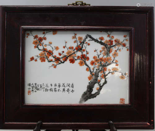 A framed Chinese porcelain plaque with cherry blossom decorations.