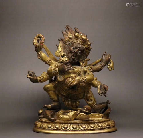 A GILT BRONZE MOLDED SIX-ARM BUDDHA STATUE