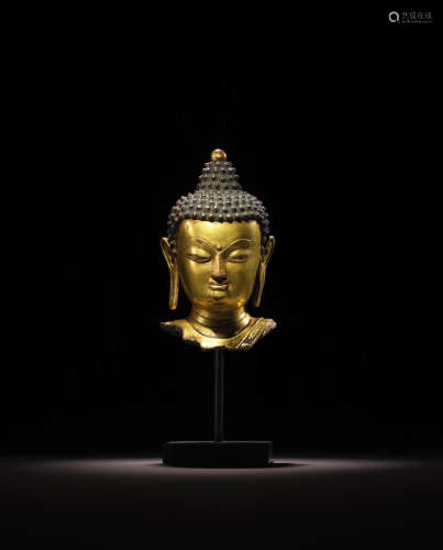 TIBET, 15TH CENTURY A GILT COPPER ALLOY HEAD OF BUDDHA