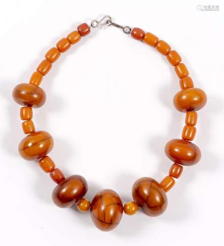 Collier composé de 7 perles d'ambre rondes et aplaties, deux petites perles d'ambre [...]