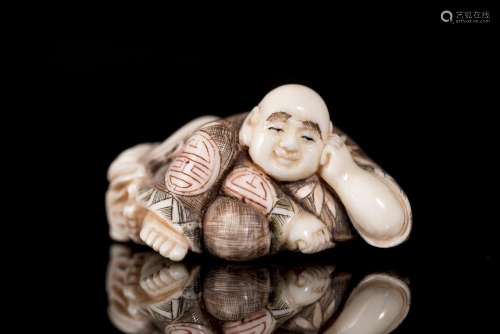 Netsuke en ivoire représentant un homme accoudé, l'éventail caché sous son [...]