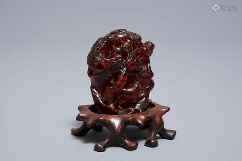 A Chinese carved amber group of a tiger below a pine tree, 19/20th C.