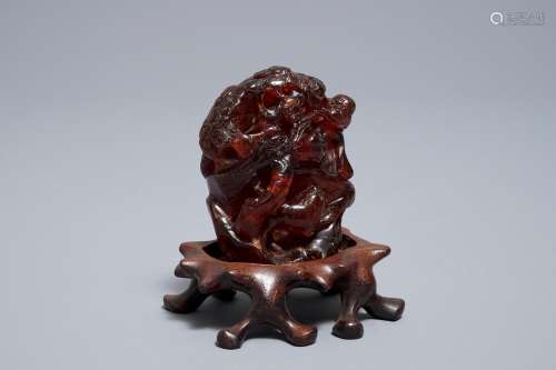 A Chinese carved amber group of a tiger below a pine tree, 19/20th C.