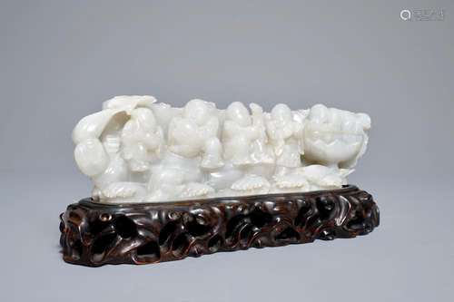 A Chinese white jade group with boys on a raft on carved wooden base, Qing