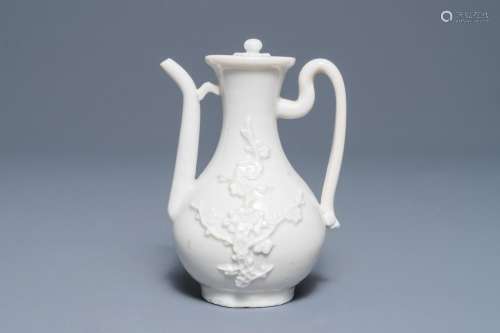 A Chinese Dehua blanc de Chine wine jug and cover with applied floral design, Kangxi