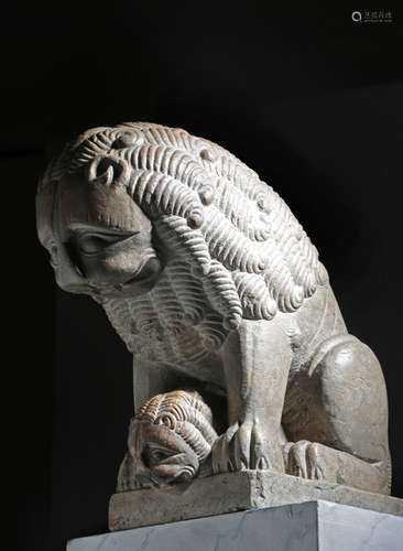 An Italian carved Verona marble group of a lion and cub in Romanesque style, both peering over a