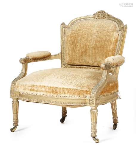 A French giltwood bergère in Louis XVI style, with a moulded frame and a surmount carved with