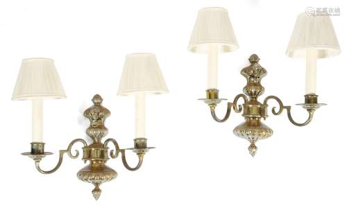 A set of four brass wall lights in Dutch Baroque style, each with an urn applied with a winged