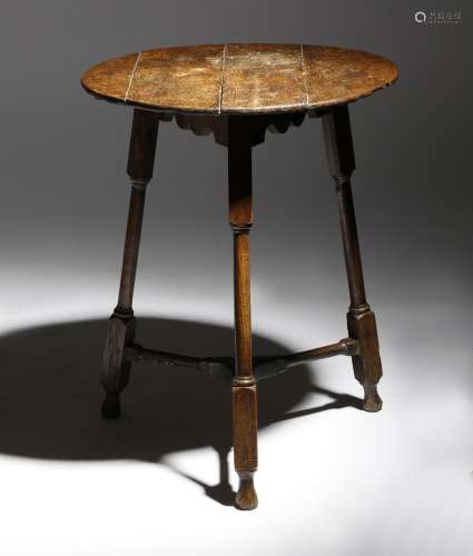 An 18th century oak cricket table, the circular boarded top made from 17th century panelling, on
