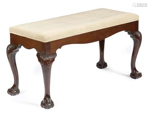 A mahogany stool in George II style, the stuffed-over seat on leaf capped cabriole legs and claw and