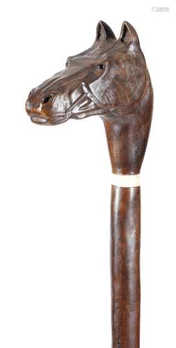 A folk art treen staff, the handle carved in the form of a horse's head, with glass eyes, above a