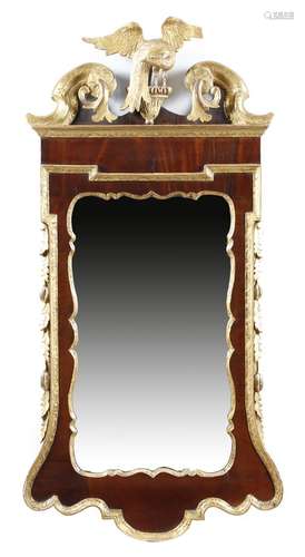 A mahogany and parcel gilt wall mirror in George II style, the shaped plate within a moulded slip,