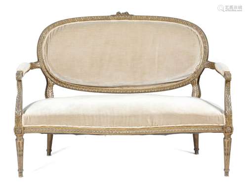 A French giltwood canapé in Louis XVI style, with a padded back, seat and armrests upholstered in