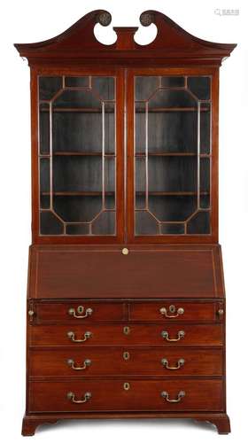 A mahogany bureau bookcase, the swan neck pediment carved with rosettes, above a pair of astragal