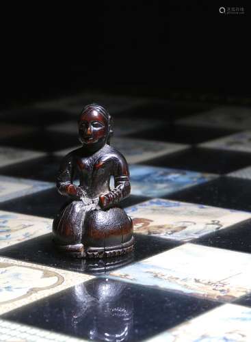 λ A rare Mughal carved ivory chess piece, of a kneeling Indian lady, above a ridged edge, with a