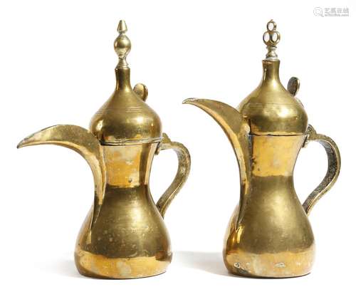 Two 19th century Arabic brass coffee pots or dallah, of typical form, one with a turned finial and a