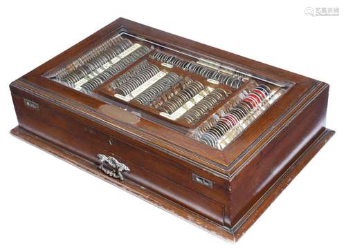 An Edwardian walnut ophthalmological doctor's lens cabinet, the glazed hinged lid inset with a brass