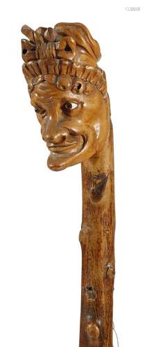 A Victorian folk art treen blackthorn walking cane, the handle carved with a grotesque bust of Judy,