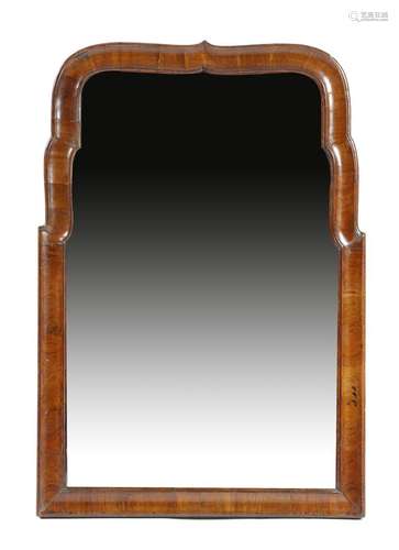 An early 18th century walnut wall mirror, the later bevelled shaped plate within a moulded frame,