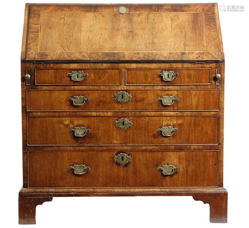 A George II walnut bureau, the hinged fall with feather and crossbanding, revealing an interior with