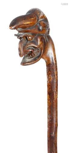 A Victorian folk art treen blackthorn walking cane, the handle carved with a grotesque bust of