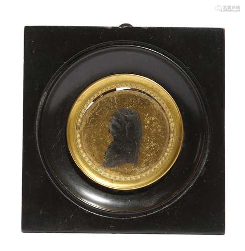 A late 18th century verre églomisé portrait silhouette, of a man, 4cm diameter, in an ebonised