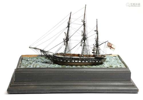 An early 20th century model three-masted sailing ship, painted wood, with a metal canon, flying