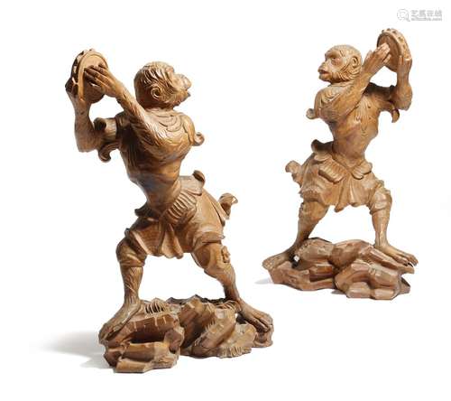 A pair of Italian Rococo style carved pine models of dancing monkeys, each playing the tambourine