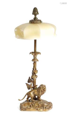 A gilt bronze table lamp, with a fir cone finial above an opaque glass shade, with twin lights,