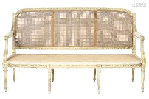 A French painted and parcel gilt canapé in Louis XVI style, with a cane back and seat, with a