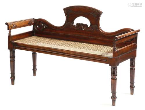 A late Regency goncalo alves window seat in the manner of Gillows, the shaped back carved with