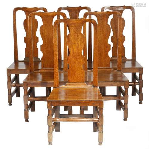 A set of six early 18th century oak dining chairs, each with a vase shaped splat above a solid seat,