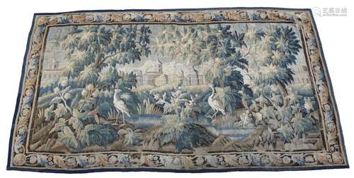 An 18th century Aubusson or Flemish verdure tapestry, worked with a château with mountains in the