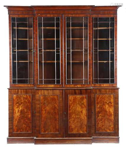 A George IV mahogany breakfront bookcase, the detachable cornice above a pair of geometric