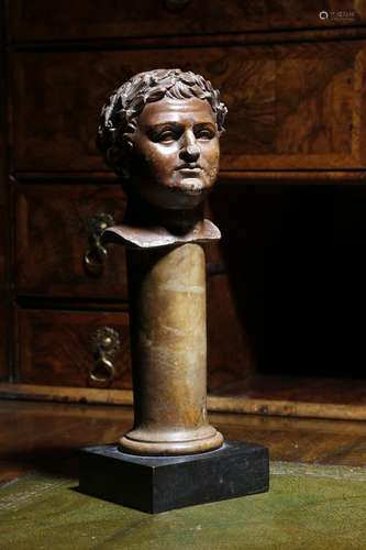 A glazed pottery Grand Tour bust of the Roman Emperor Titus, wearing a laurel wreath, mounted on