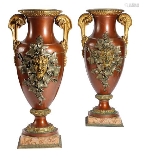 A pair of French gilt and patinated bronze urns, of amphora shape, the bodies decorated with a