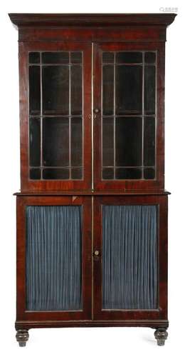 A George IV mahogany bookcase cabinet, with a dentil cornice, above a pair of astragal glazed doors,