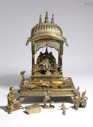 An Indian brass shrine, the canopy with three turned finials, with pierced decoration and